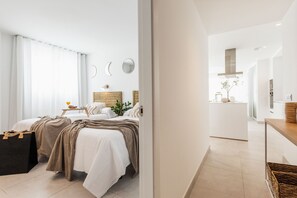 A modern hotel room with two beds, a small kitchenette, and a view of the city. - Apartamentos Martalia Nerja (Torrox)