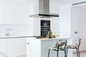 Una cucina moderna con isola centrale, elettrodomestici in acciaio inossidabile e forno integrato.