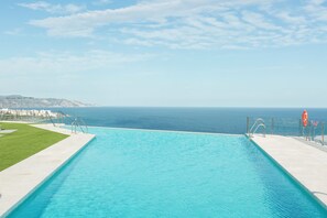 A swimming pool with a clear view of the ocean and a distant mountain range. - Apartamentos Martalia Nerja (Torrox)