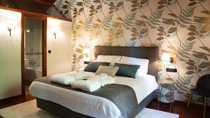 A bedroom with a large bed, a shower, and a bathroom visible through an open door. - Snö Pazo de Adran (Teo)