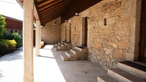 A stone building with a covered porch and steps leading to a door. - Snö Pazo de Adran (Teo)