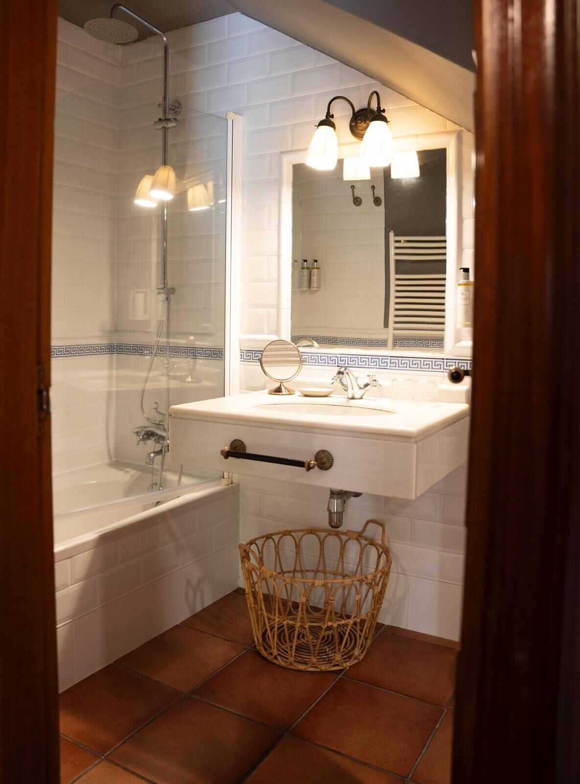 A bathroom with a bathtub, a sink with a mirror, and a shower.