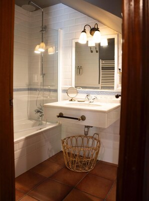 A bathroom with a bathtub, a sink with a mirror, and a shower. - Snö Pazo de Adran (Teo)