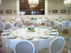 A banquet hall with round tables set for dining, each with white tablecloths, chairs, and centerpieces. - Snö Pazo de Adran (Teo)
