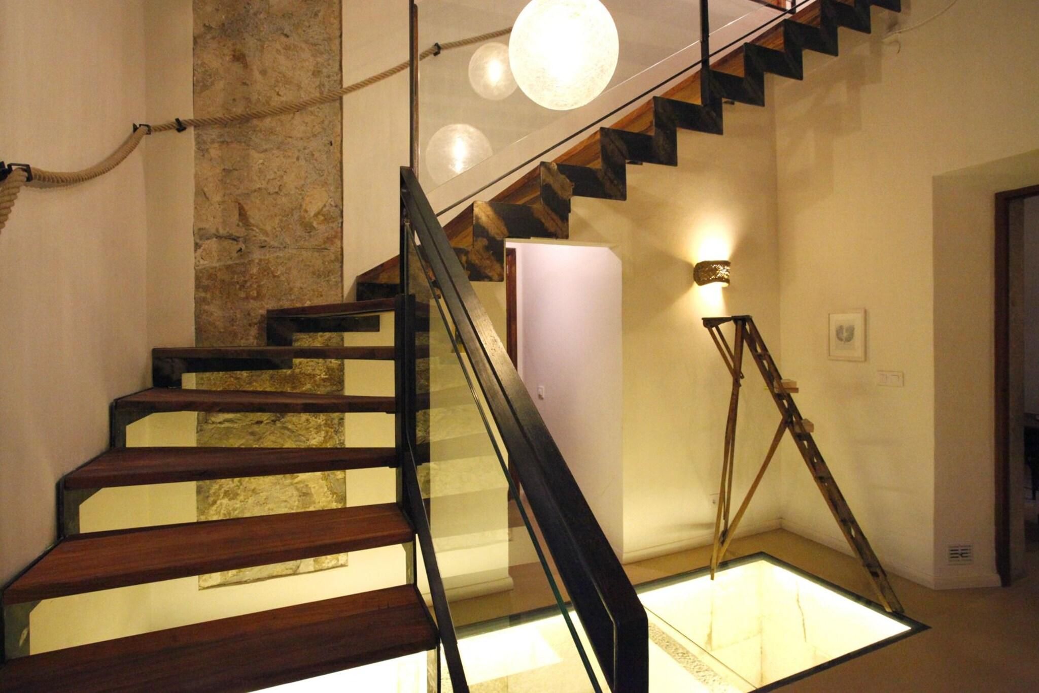 Una escalera con peldaños de madera y un panel de vidrio en la parte inferior.