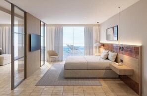 A modern hotel room with a large bed, a TV, a desk, and a view of the ocean. - Estival Maramar (El Vendrell)