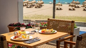 A table set for two with plates of food, glasses of wine, and cutlery. - Estival Maramar (El Vendrell)