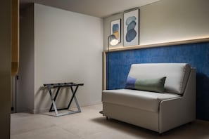 A modern living room with a white sofa, a small table, and abstract art on the wall. - Estival Maramar (El Vendrell)