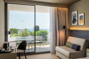 A hotel room with a balcony, a sofa, a desk, and a chair. - Estival Maramar (El Vendrell)
