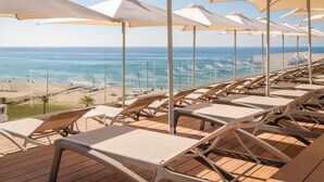 A deck with sun loungers and umbrellas overlooking a beach. - Estival Maramar (El Vendrell)