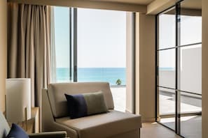 A hotel room with a view of the ocean, a sofa, and a lamp. - Estival Maramar (El Vendrell)