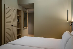 A bedroom with a bed, a wardrobe with sliding doors, and a mirror on the wall. - Estival Maramar (El Vendrell)