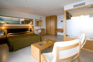 A modern hotel room with a bed, a desk, a chair, a wardrobe, and a painting on the wall. - R2 Bahía Design Hotel & Spa Wellness - Adults Only (Tuineje)