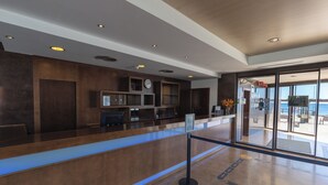 A reception area with a wooden reception desk, a clock, and a glass door leading outside.