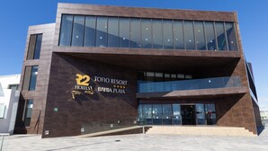 A modern building with a sign for "Tofio Resort Bahia Playa".