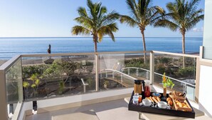 A balcony with a breakfast tray, palm trees, and a view of the ocean. - R2 Bahía Design Hotel & Spa Wellness - Adults Only (Tuineje)