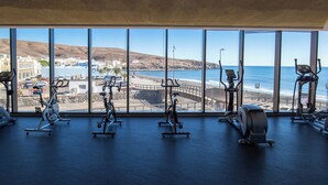 A gym with exercise equipment and a view of the beach. - R2 Bahía Design Hotel & Spa Wellness - Adults Only (Tuineje)