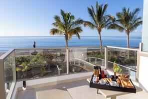 A balcony with a breakfast tray, palm trees, and a view of the ocean. - R2 Bahía Design Hotel & Spa Wellness - Adults Only (Tuineje)
