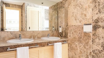 A bathroom with two sinks, a large mirror, and a towel rack.