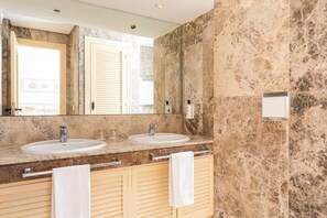 A bathroom with two sinks, a large mirror, and a towel rack. - Ona Las Lomas Village (Cartagena)