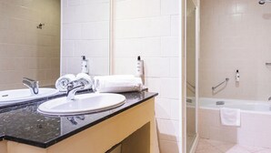 A modern bathroom with a double sink, a glass shower enclosure, and a bathtub. - Ona Las Lomas Village (Cartagena)