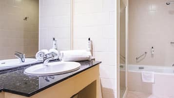 A modern bathroom with a double sink, a glass shower enclosure, and a bathtub.