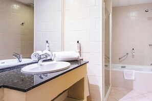 A modern bathroom with a double sink, a glass shower enclosure, and a bathtub. - Ona Las Lomas Village (Cartagena)