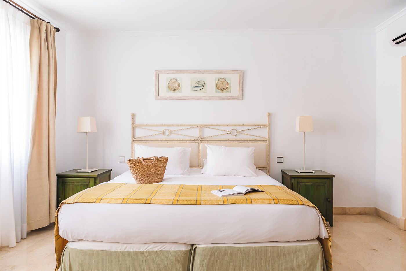 Een netjes ingerichte slaapkamer met een bed, twee nachtkastjes, een hoofdbord en een ingelijste foto aan de muur.