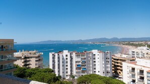 Zona residencial costera con edificios altos, una playa y un cielo azul despejado.