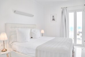 A hotel room with a large bed, two bedside lamps, a framed picture on the wall, and a view of the sea through the window. - Hotel Zhero-palma (Calvia)