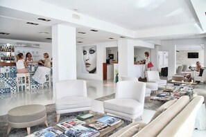 A modern, spacious living area with white furniture, a bar, and a large wall art piece. - Hotel Zhero-palma (Calvia)