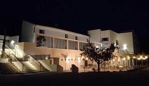 A modern building with a staircase, outdoor seating, and a tree in the foreground. - Hotel Boutique Molino De Enmedio (Hueneja)
