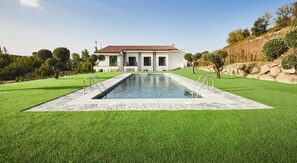 A modern house with a swimming pool, surrounded by well-maintained grass and trees. - Hotel Boutique Molino De Enmedio (Hueneja)