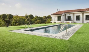 A modern house with a swimming pool, surrounded by well-maintained lawn and trees. - Hotel Boutique Molino De Enmedio (Hueneja)