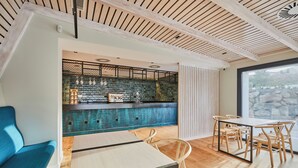 A modern interior with a bar area, seating, and a view through a large window. - Hotel Boutique Molino De Enmedio (Hueneja)
