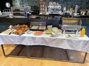 A buffet setup with various food items, a coffee machine, and a juice dispenser. - Hotel Boutique Molino De Enmedio (Hueneja)