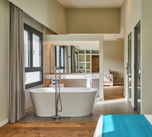 A modern bathroom with a freestanding bathtub, a large mirror, and a wooden floor. - Hotel Boutique Molino De Enmedio (Hueneja)