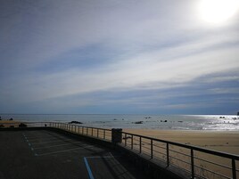 A parking area with a view of the beach and ocean.