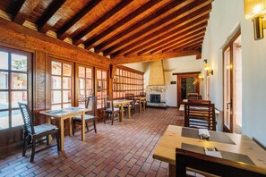A rustic dining area with wooden tables and chairs, brick flooring, and exposed wooden beams. - Abba Las Viñas Tiedra Hotel Rural (Tiedra)