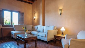 A cozy living room with a sofa, two armchairs, a coffee table, and a lamp.