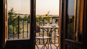 A balcony with a table set for two, featuring a vase with sunflowers and two wine glasses. - Abba Las Viñas Tiedra Hotel Rural (Tiedra)
