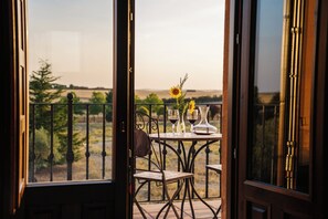 A balcony with a table set for two, featuring a vase with sunflowers and two wine glasses. - Abba Las Viñas Tiedra Hotel Rural (Tiedra)