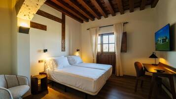 A bedroom with a bed, bedside tables, a desk, and a chair.