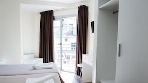 A hotel room with two beds, a balcony, a desk, and a chair. - Celymar (Benidorm)