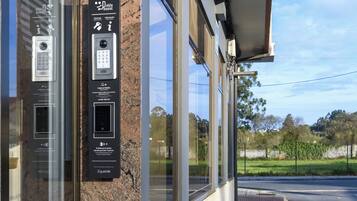 A security keypad and card reader mounted on a building facade.