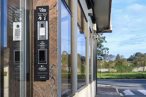 A security keypad and card reader mounted on a building facade. - Alda Narón (Naron)