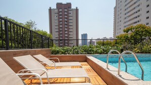 A rooftop pool area with lounge chairs and a swimming pool. - Perdizes Smart Experience - Allianz (São Paulo)