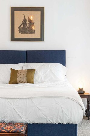 Tabla de planchar con plancha, internet y ropa de cama