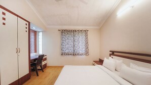 Ein Schlafzimmer mit Bett, Schreibtisch und Kleiderschrank.