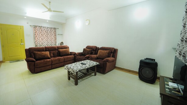 A living room with a sofa set, a coffee table, a television, and a speaker. - Amazing Hridayam 2-bedroom bungalow in Panchgani (Panchgani)